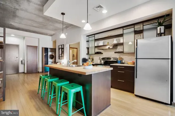a kitchen with kitchen island a stove and a refrigerator
