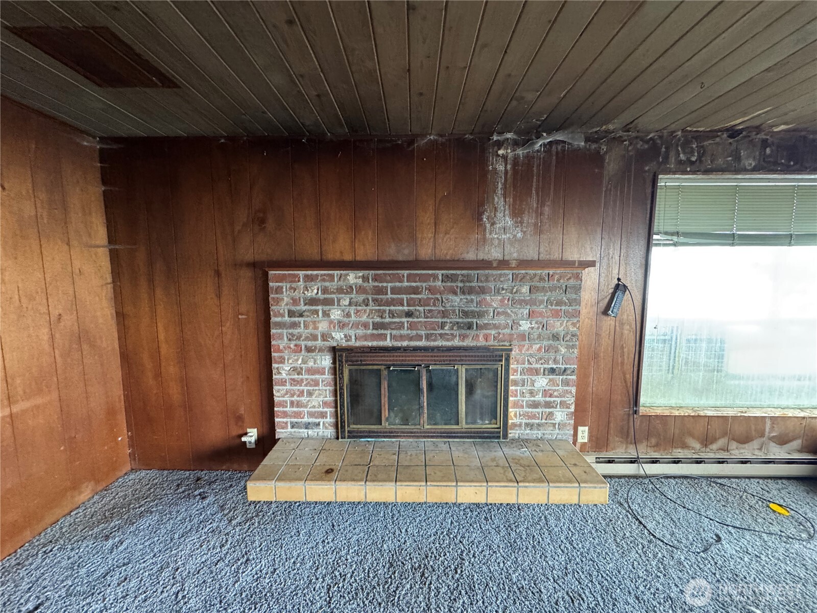 1284 Dines Point Road Greenbank, WA 98253 - Photo 5 of 39 a living room with a fireplace wooden floor and a table