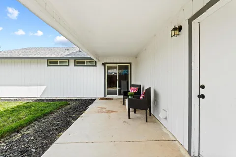 a view of a house with backyard sitting area and tub