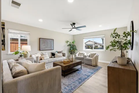 a living room with furniture a chandelier and a window
