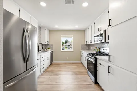 a kitchen with stainless steel appliances a refrigerator sink and cabinets