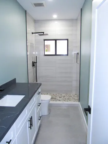 a open kitchen with stainless steel appliances granite countertop a refrigerator a sink dishwasher a stove and a dining table with wooden floor