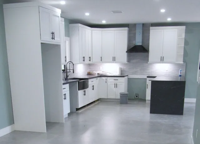 a kitchen with stainless steel appliances granite countertop a sink a stove and a refrigerator