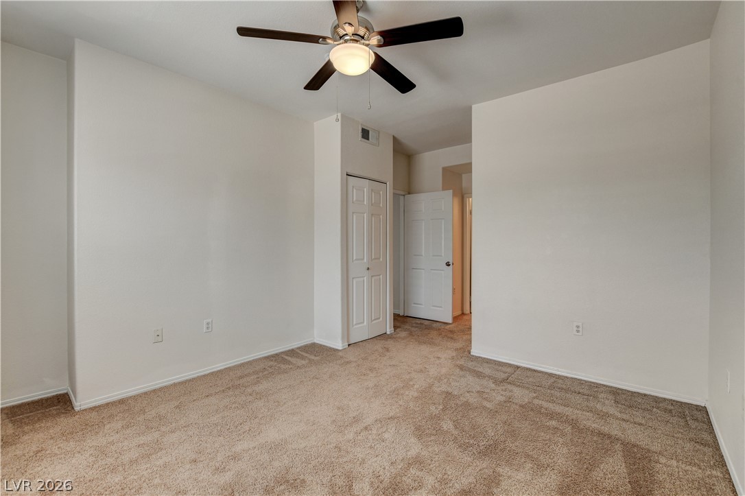 3318 North Decatur Boulevard, Unit 1069 Las Vegas, NV 89130 - Photo 25 of 39 A spacious bedroom features soft carpet flooring and a practical ceiling fan with illumination.