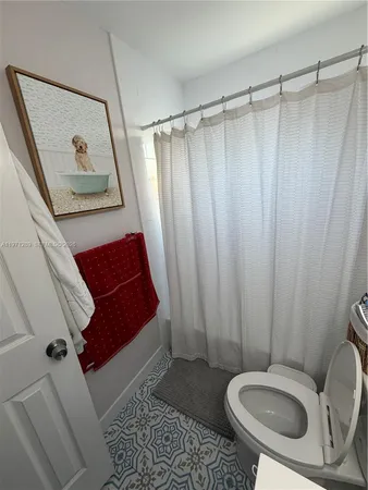 a bathroom with a toilet and a shower curtain