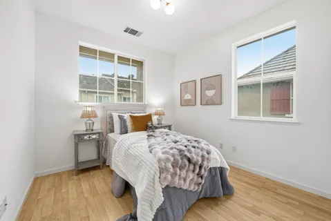 a bedroom with bed and wooden floor