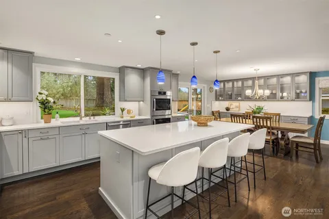a kitchen with a sink a stove a refrigerator and white cabinets