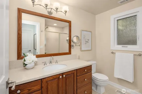 a bedroom with a bed and a lamp on dresser