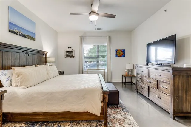 a bedroom with a bed a chandelier and dresser