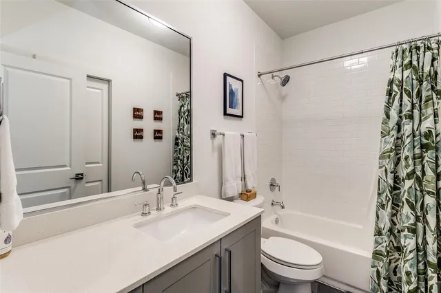 a bathroom with a sink a toilet a mirror a bathtub and shower