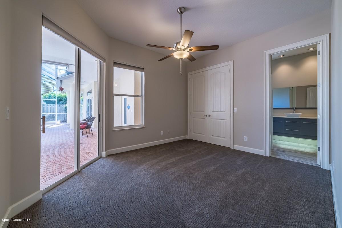 1725 Canterbury Drive Indialantic, FL 32903 - Photo 20 of 22 an empty room with chandelier fan and windows