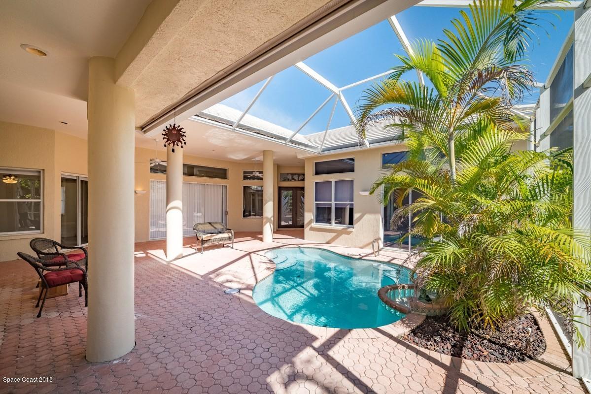 1725 Canterbury Drive Indialantic, FL 32903 - Photo 2 of 22 a front view of a house with a yard glass top table and chairs