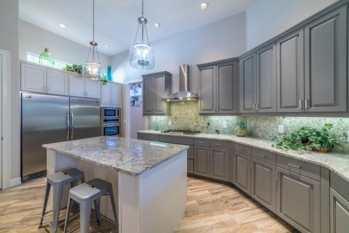 1725 Canterbury Drive Indialantic, FL 32903 - Photo 5 of 22 a kitchen with stainless steel appliances granite countertop a kitchen island a stove a table and chairs in it
