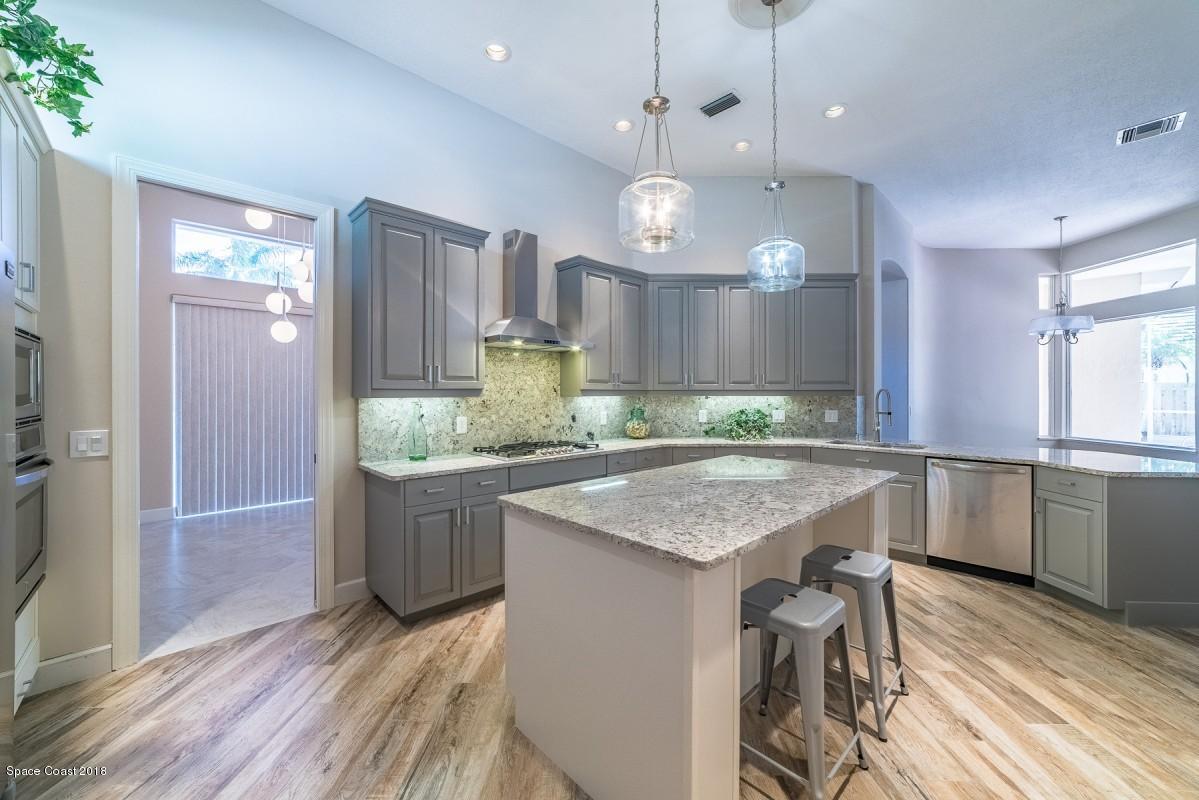 1725 Canterbury Drive Indialantic, FL 32903 - Photo 6 of 22 a kitchen with granite countertop a stove a sink and wooden floor