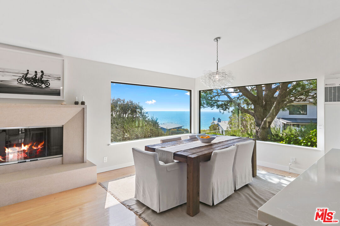 6801 Seawatch Lane Malibu, CA 90265 - Photo 4 of 34 a dining room with fireplace furniture and a floor to ceiling window