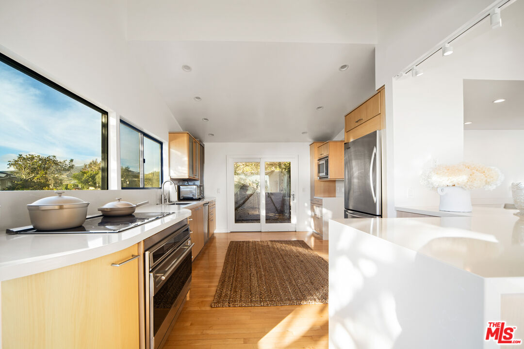 6801 Seawatch Lane Malibu, CA 90265 - Photo 9 of 34 a kitchen with stainless steel appliances granite countertop a sink and a stove