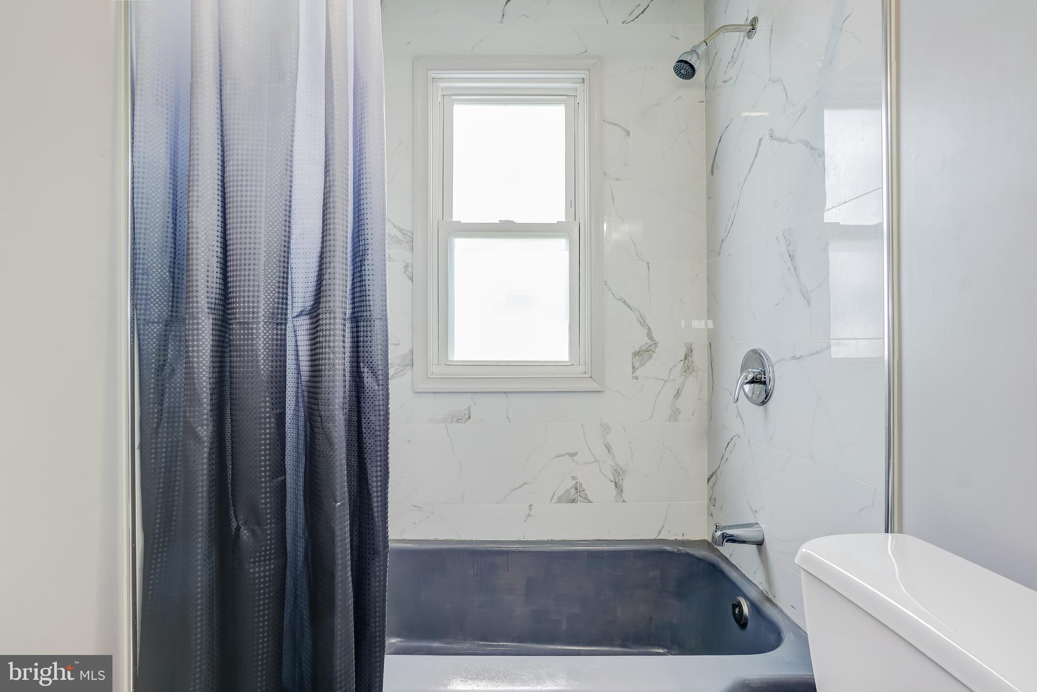 8 Avenal Road Essex, MD 21221 - Photo 12 of 17 a bathroom with a sink a toilet a window and shower