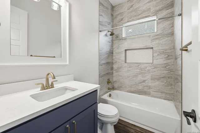 a bathroom with a sink mirror toilet and bathtub