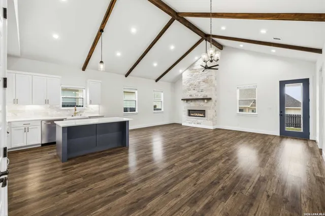 a large kitchen with stainless steel appliances granite countertop a dishwasher and a stove with wooden floors