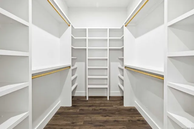 a view of walk in closet with empty racks