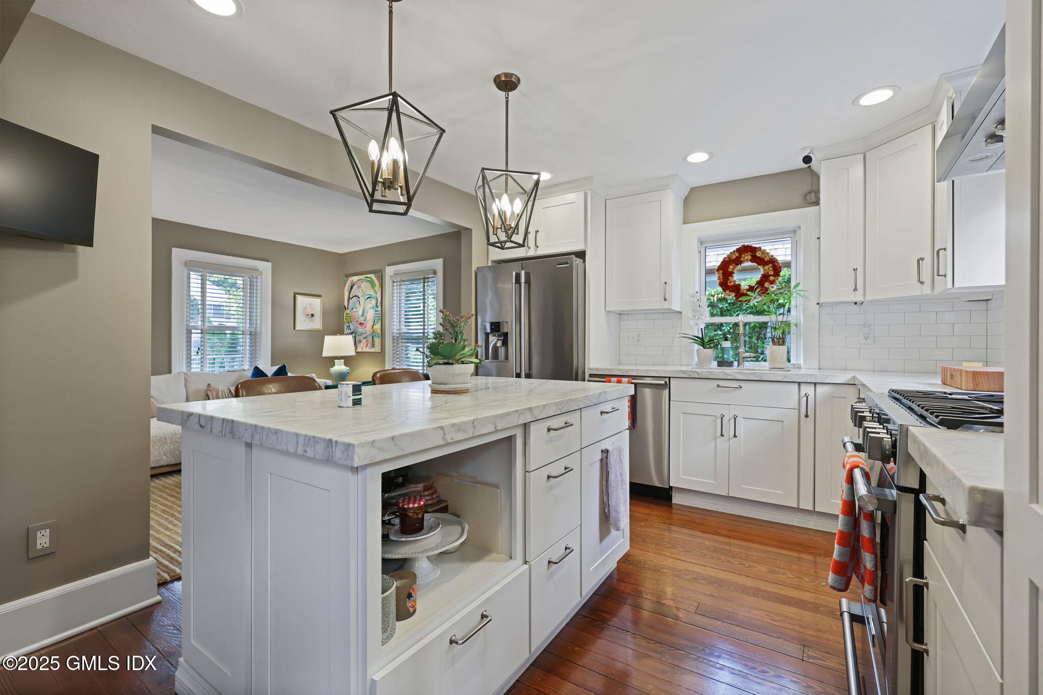 9 Cottage Place Greenwich, CT 06830 - Photo 8 of 21 a kitchen with kitchen island granite countertop a stove a sink a refrigerator and a dining table with wooden floor