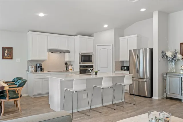 a kitchen with stainless steel appliances a refrigerator and a stove top oven