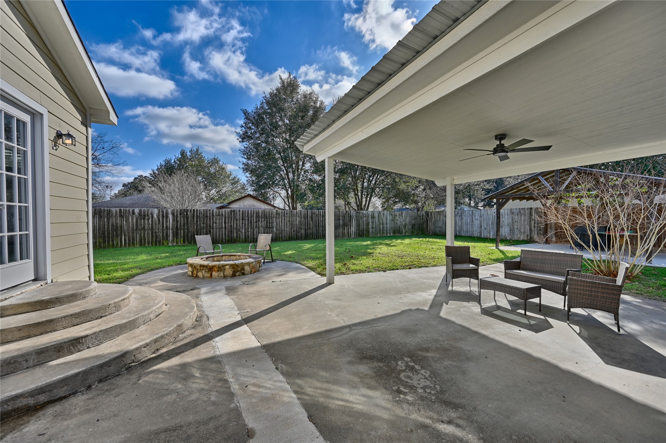 1702 Rampart Street Columbus, TX 78934 - Photo 17 of 38 Fenced backyard with a patio, an outdoor living space with a fire pit, and ceiling fan