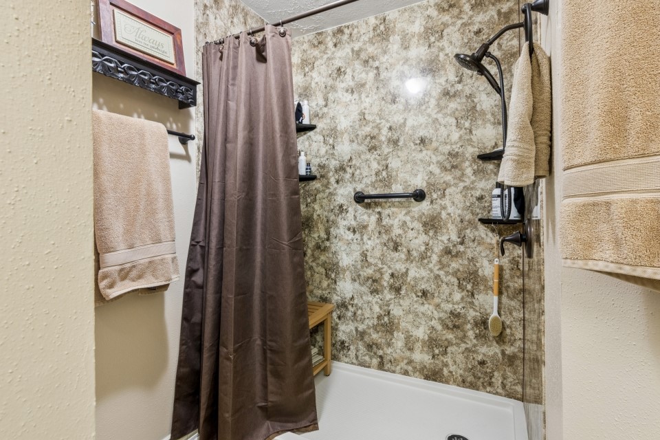 9211 Benwick Street Spring, TX 77379 - Photo 18 of 27 a bathroom with a shower and a glass door