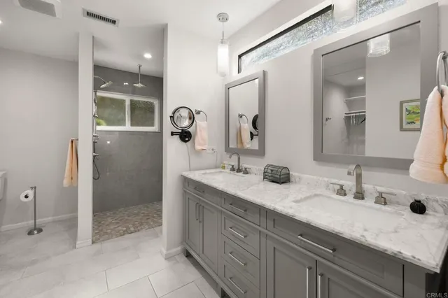 a bathroom with a granite countertop sink mirror and shower