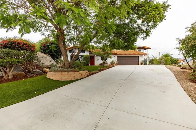 a view of a house with backyard sitting area and garden