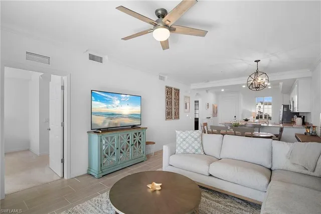a living room with furniture a chandelier and a flat screen tv