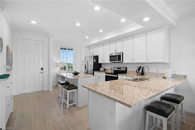a kitchen with granite countertop sink cabinets and wooden floor
