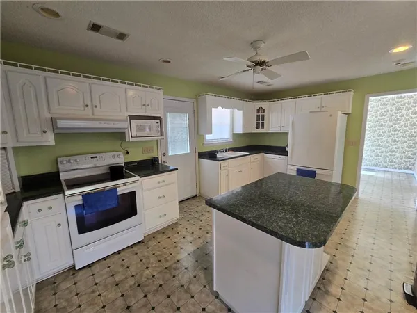 a kitchen with stainless steel appliances granite countertop a sink stove and cabinets