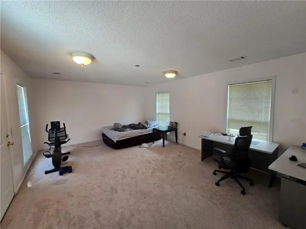 a bed sitting in a bedroom next to a window