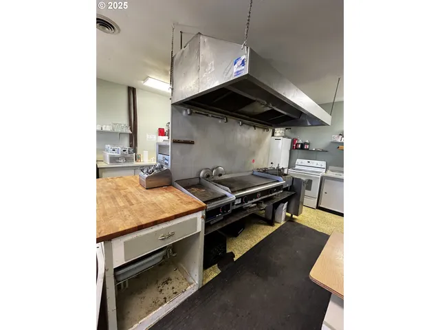 a kitchen with stainless steel appliances granite countertop a sink a stove and a microwave