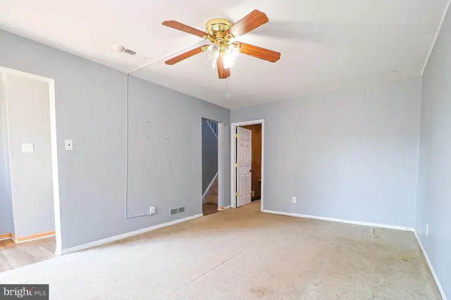 an empty room with closet and a chandelier fan
