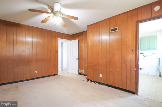 an empty room with fan and entrance