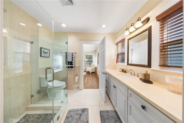 a spacious bathroom with a double vanity sink a mirror and a toilet