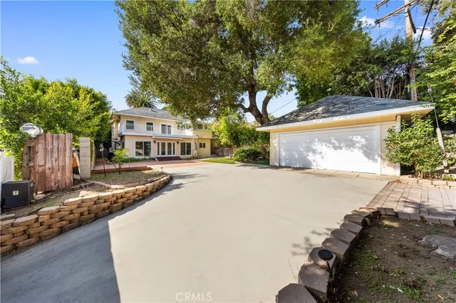 a front view of a house with a yard and trees