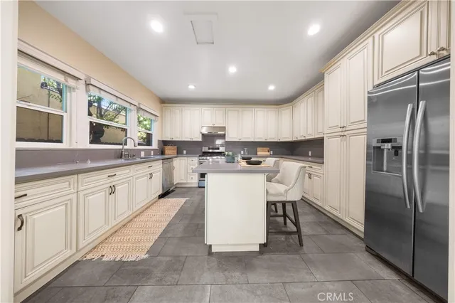 a kitchen with a refrigerator a sink and cabinets