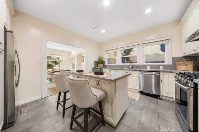 a kitchen with appliances a sink a counter top space and cabinets
