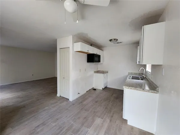 a kitchen with a sink cabinets and wooden floor