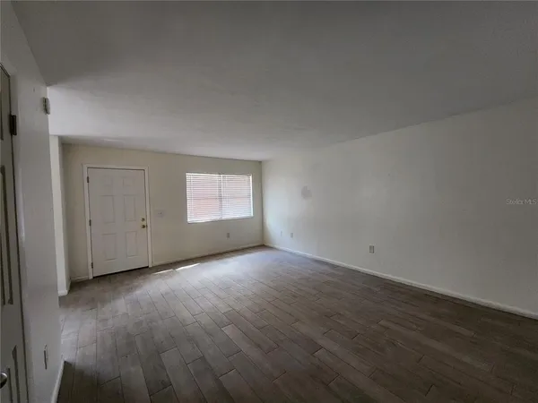 a view of an empty room and wooden floor