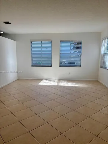 an empty room with white walls and tiles