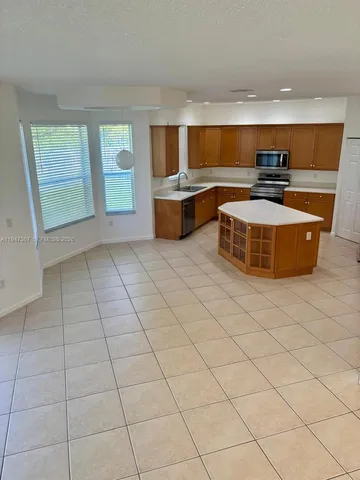 a kitchen with stainless steel appliances a stove a sink a refrigerator and a oven