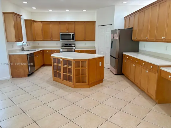 a kitchen with stainless steel appliances a stove a sink a refrigerator and cabinets