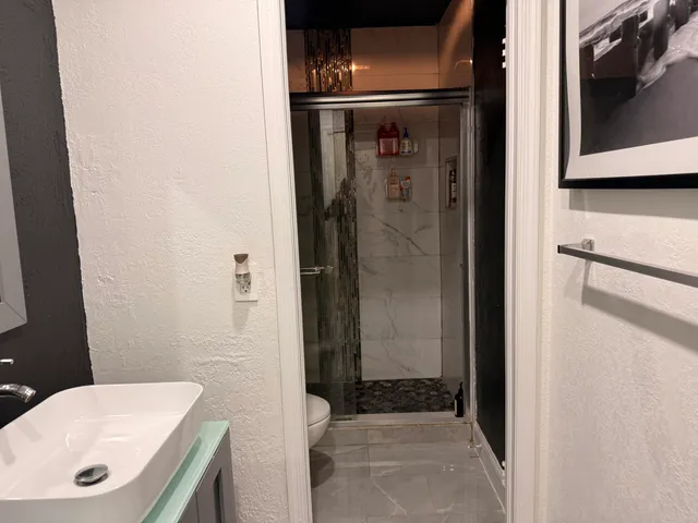 a bathroom with a sink a toilet and shower