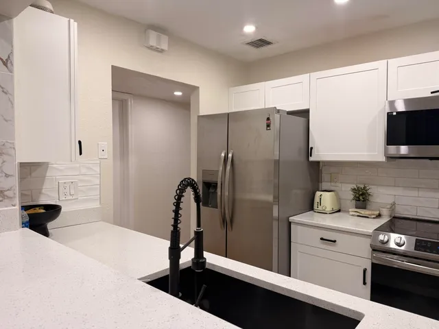 a kitchen with a refrigerator and a stove