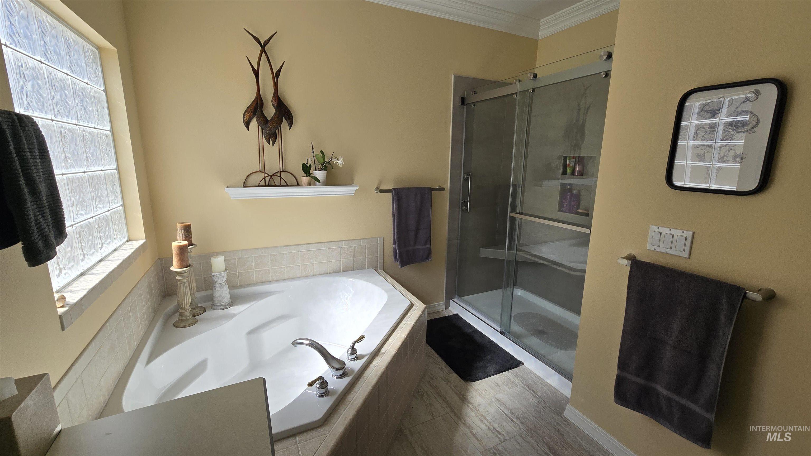 2898 North Silverleaf Way Meridian, ID 83646 - Photo 12 of 26 Full bath with a garden tub, a shower stall, crown molding, and light wood-style flooring