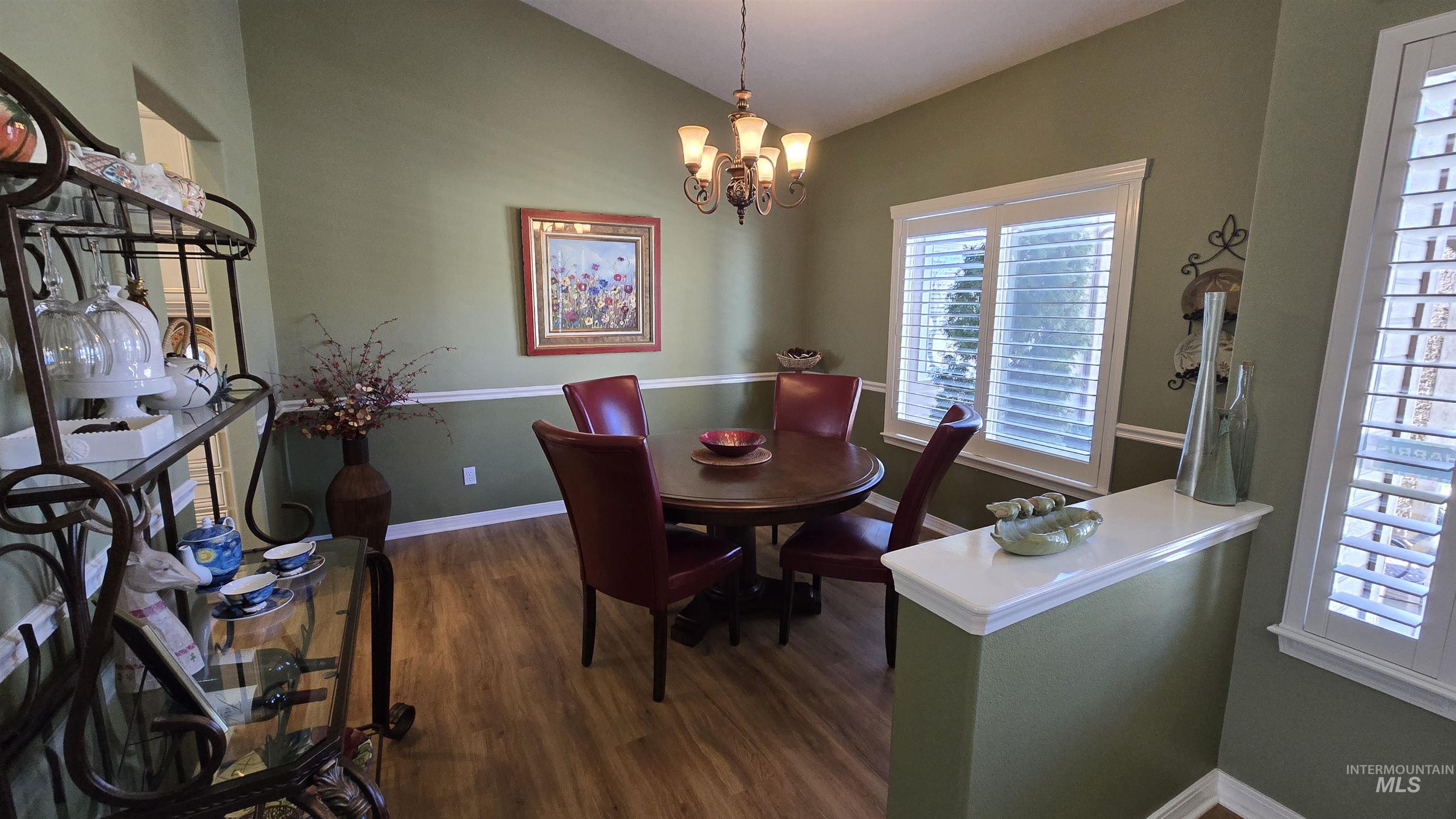 2898 North Silverleaf Way Meridian, ID 83646 - Photo 17 of 26 Dining space featuring dark wood-type flooring, a chandelier, and lofted ceiling